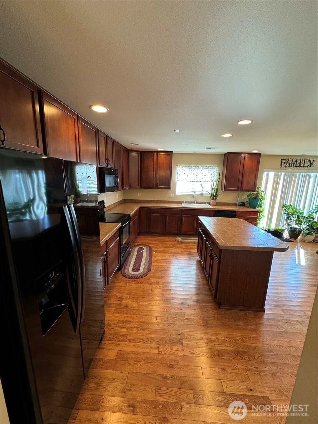 1175 Swan Loop DuPont, WA 98327 - Photo 10 of 34 a kitchen with stainless steel appliances granite countertop a refrigerator a sink dishwasher a stove and a dining table with wooden floor