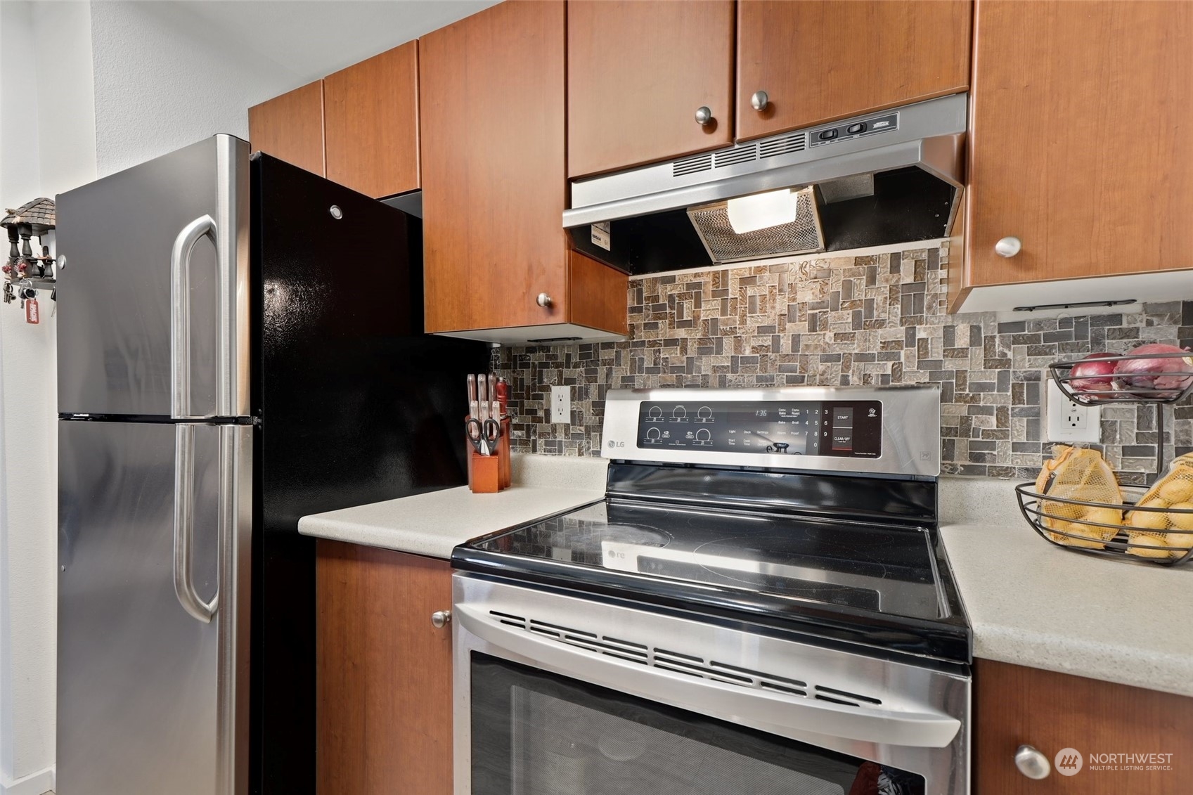 12404 East Gibson Road, Unit J103 Everett, WA 98204 - Photo 13 of 40 a kitchen with stainless steel appliances wooden cabinets and a stove top oven