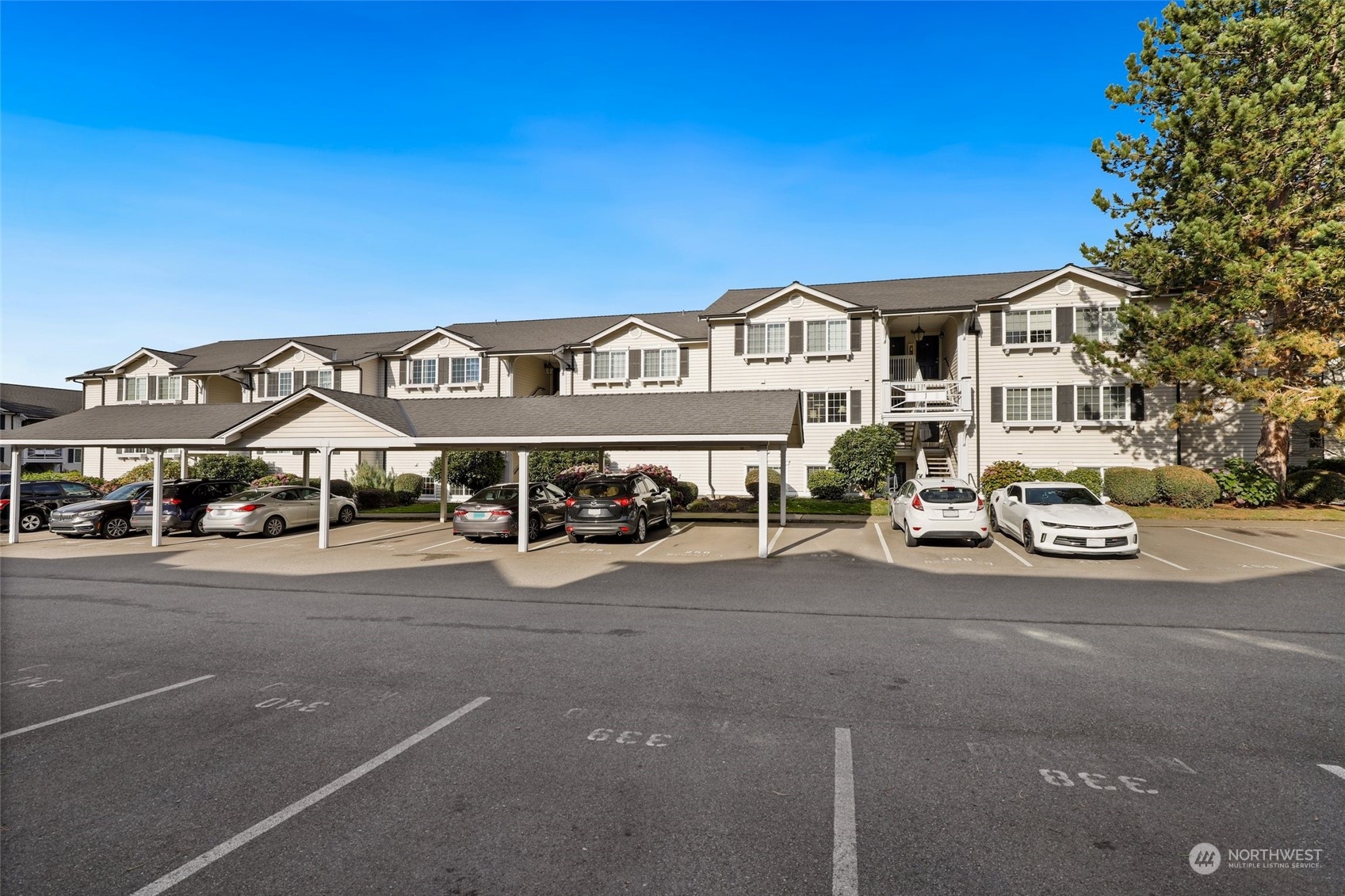 12404 East Gibson Road, Unit J103 Everett, WA 98204 - Photo 32 of 40 a front view of a house with a garden and parking space