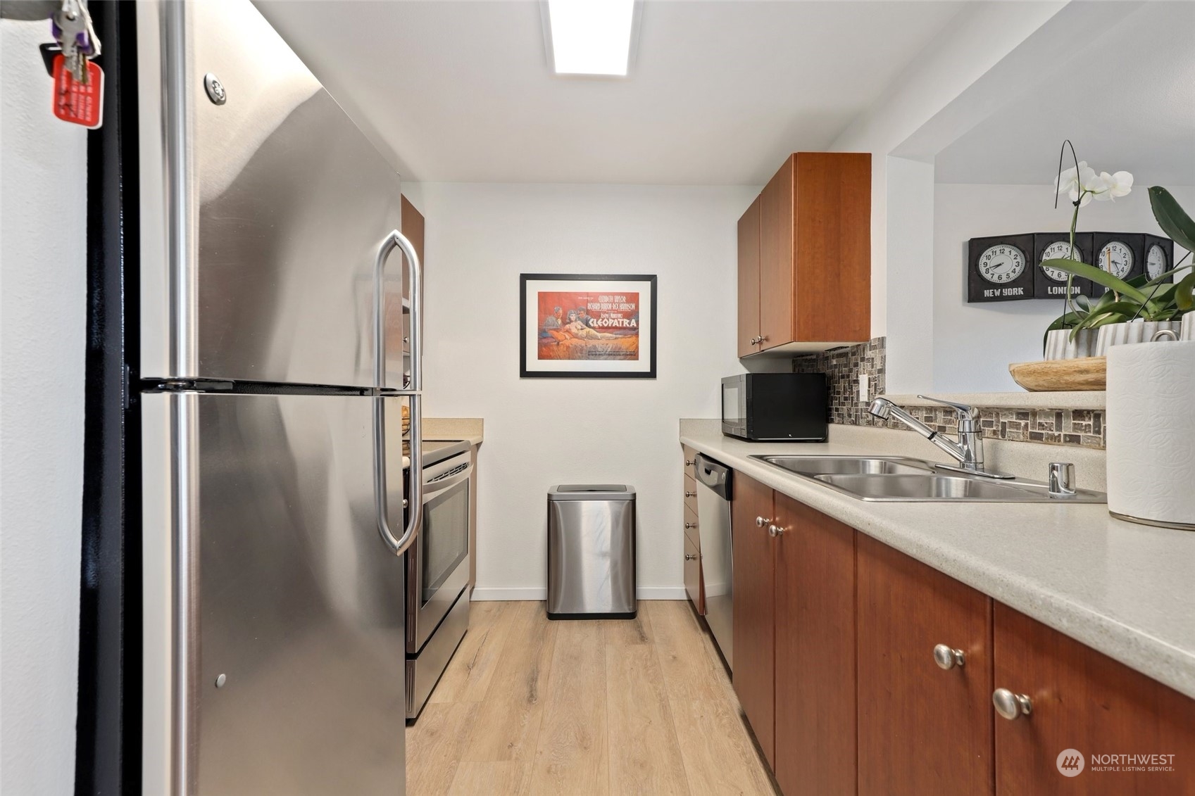 12404 East Gibson Road, Unit J103 Everett, WA 98204 - Photo 10 of 40 a kitchen with stainless steel appliances a refrigerator sink and wooden floor