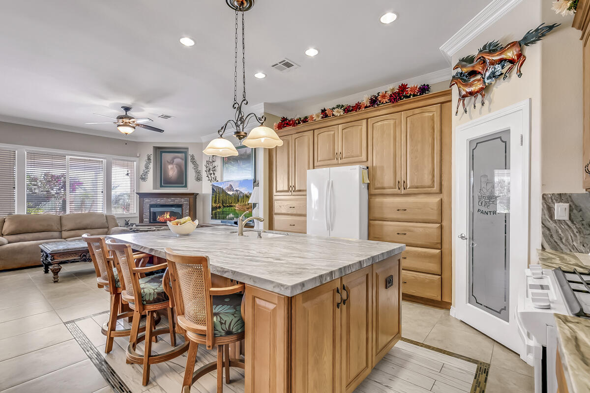 2902 Treadwell Boulevard Thermal, CA 92274 - Photo 44 of 88 a kitchen with stainless steel appliances kitchen island granite countertop a table chairs and a refrigerator