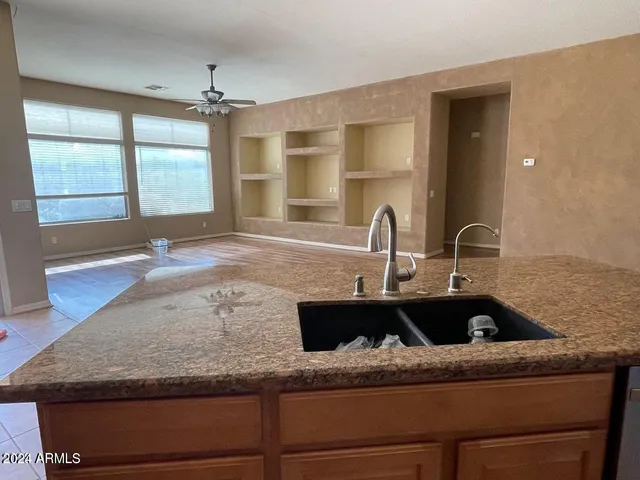 a kitchen with granite countertop a sink stove and refrigerator