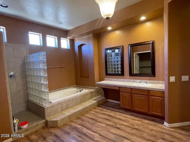 a view of a bathroom with mirror and shower
