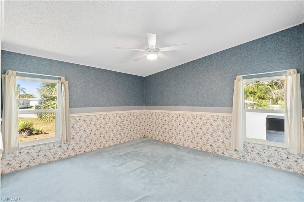 278 Riverwood Road Naples, FL 34114 - Photo 13 of 43 Spare room featuring wallpapered walls, carpet flooring, a wainscoted wall, and ceiling fan