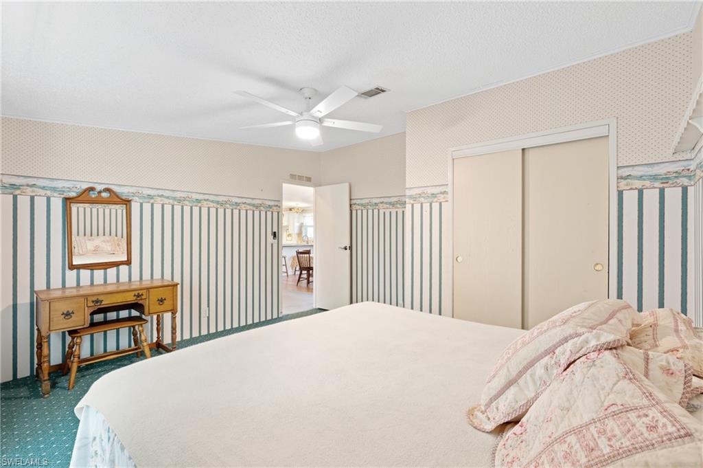 278 Riverwood Road Naples, FL 34114 - Photo 17 of 43 Bedroom with visible vents, carpet, and wallpapered walls