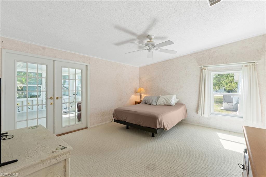 278 Riverwood Road Naples, FL 34114 - Photo 18 of 43 Carpeted bedroom featuring visible vents, french doors, a textured ceiling, crown molding, and access to outside