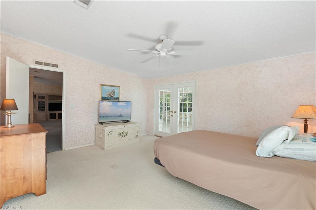 278 Riverwood Road Naples, FL 34114 - Photo 19 of 43 Bedroom featuring wallpapered walls, visible vents, access to exterior, and french doors