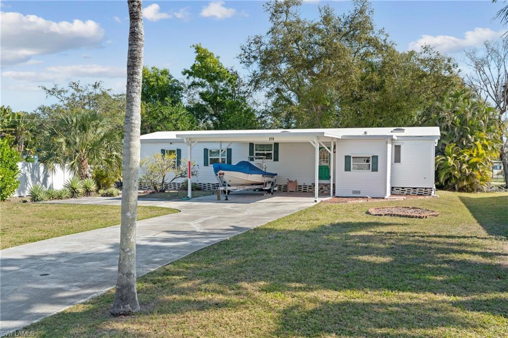 278 Riverwood Road Naples, FL 34114 - Photo 36 of 43 Manufactured / mobile home featuring a carport, crawl space, driveway, and a front yard