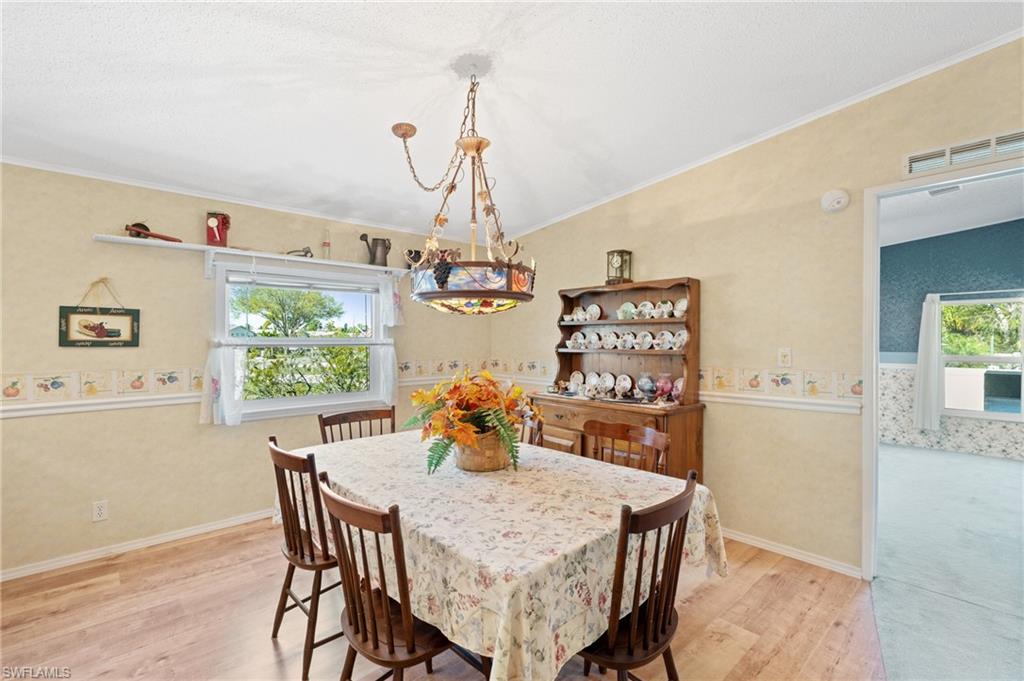 278 Riverwood Road Naples, FL 34114 - Photo 8 of 43 Dining space featuring visible vents, baseboards, light wood-style floors, and crown molding