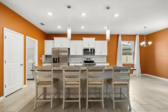 a kitchen with stainless steel appliances granite countertop a sink a stove and a refrigerator