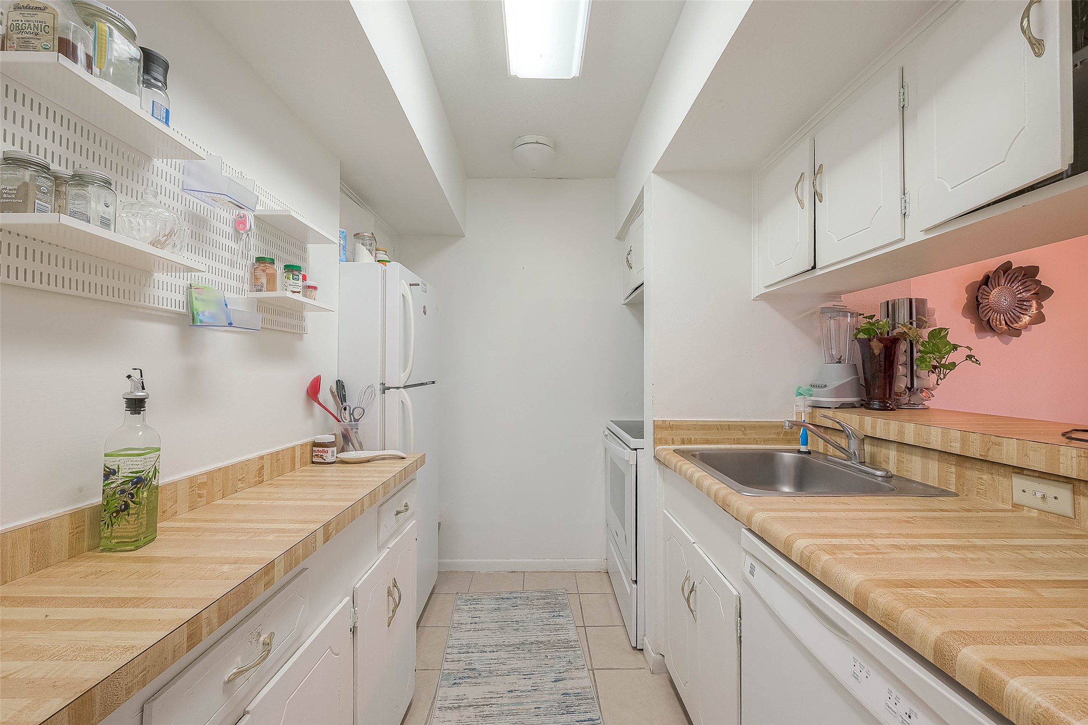 2201 Fountain View Drive, Unit 54 Houston, TX 77057 - Photo 16 of 30 a kitchen with kitchen island a sink stove and refrigerator