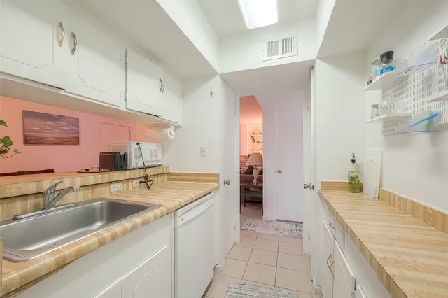 a large kitchen with a sink and a large mirror