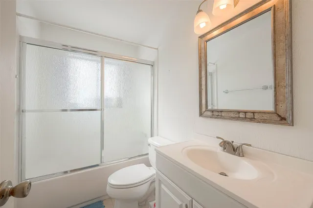 a bathroom with a sink mirror vanity and toilet