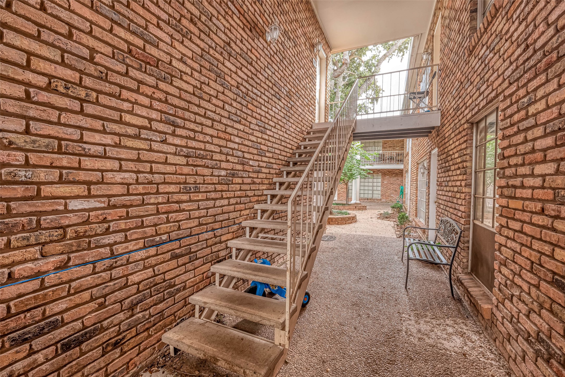 2201 Fountain View Drive, Unit 54 Houston, TX 77057 - Photo 5 of 30 a view of a pathway with a brick wall