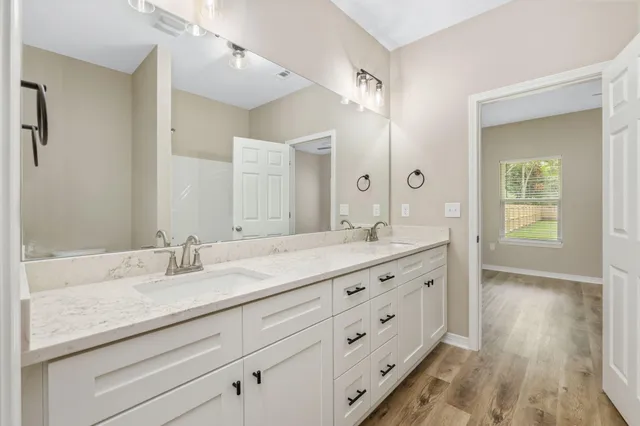 a bathroom with double sink and a mirror