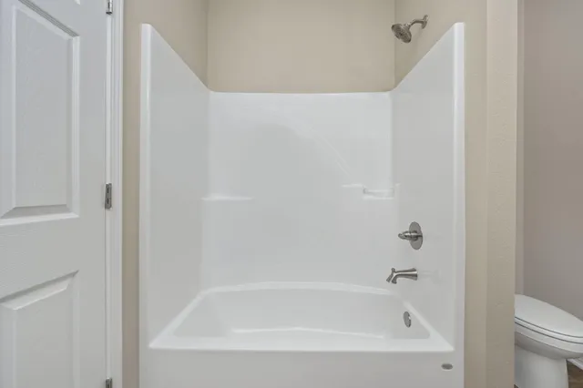 a white bath tub sitting next to a white toilet