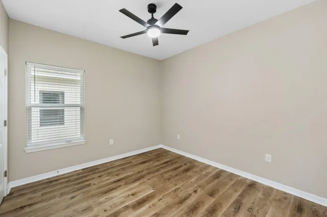 a view of a big room with wooden floor and a chandelier fan