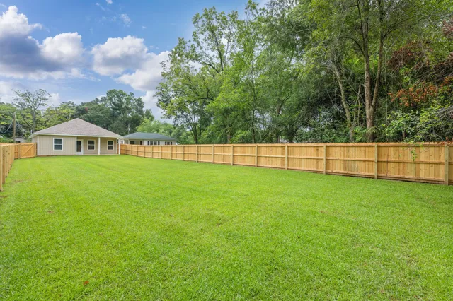a view of yard with green space and wooden fence