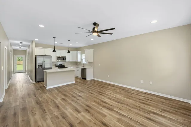 a view of kitchen with granite countertop cabinets and refrigerator