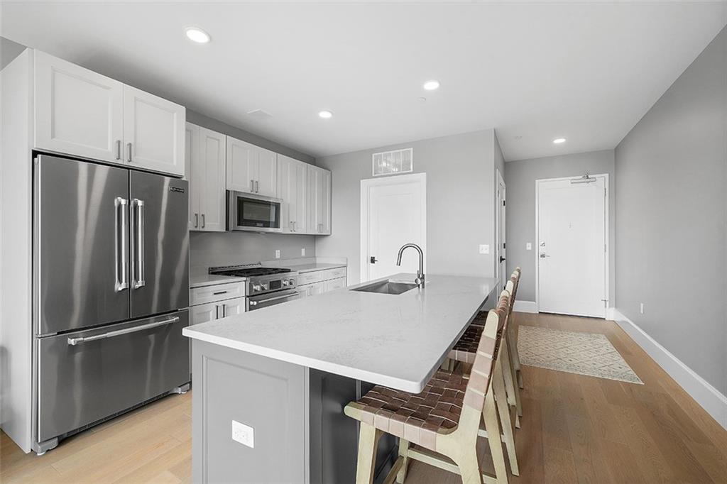 350 Oliver Avenue, Unit 1503 Pittsburgh, PA 15222 - Photo 11 of 43 a kitchen with kitchen island a refrigerator stove microwave and cabinets