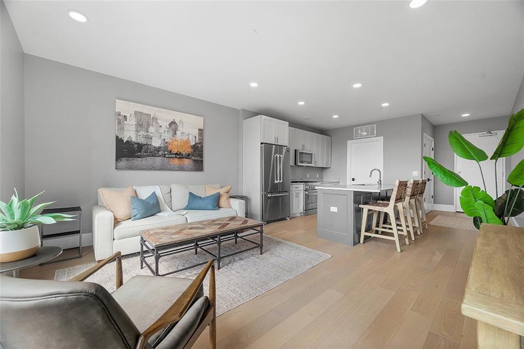 350 Oliver Avenue, Unit 1503 Pittsburgh, PA 15222 - Photo 18 of 43 a living room with furniture a potted plant and kitchen view