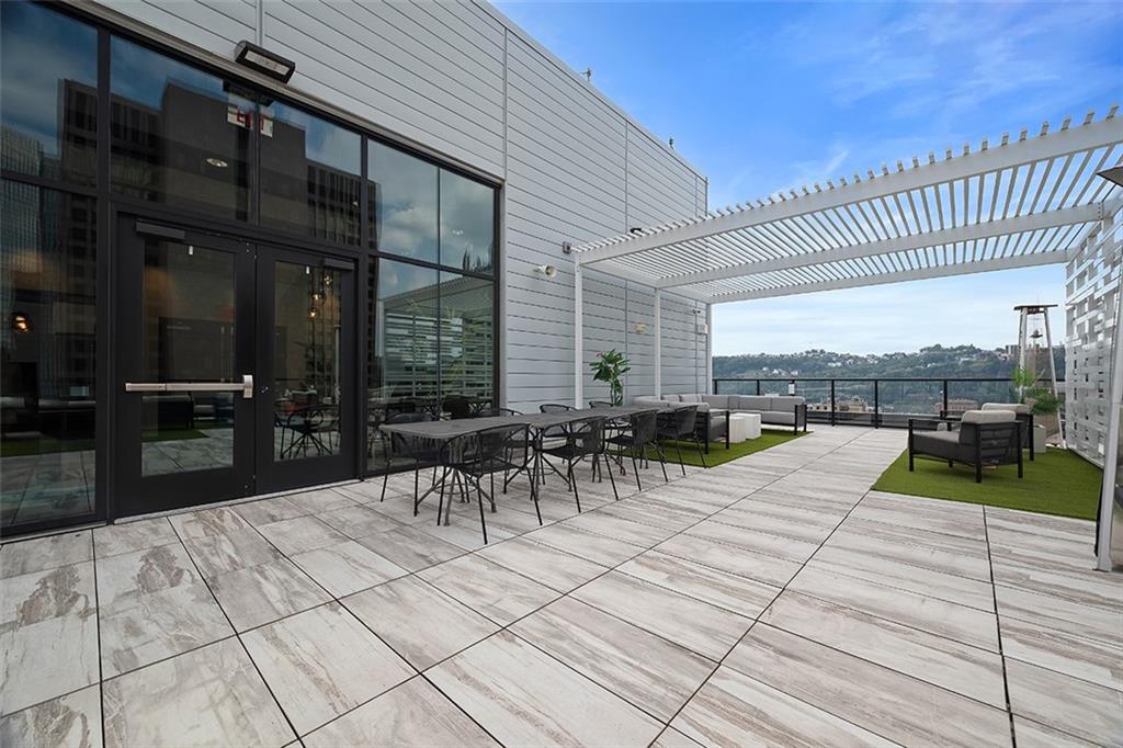 350 Oliver Avenue, Unit 1503 Pittsburgh, PA 15222 - Photo 38 of 43 a view of a patio with dining table and chairs with a wooden floor