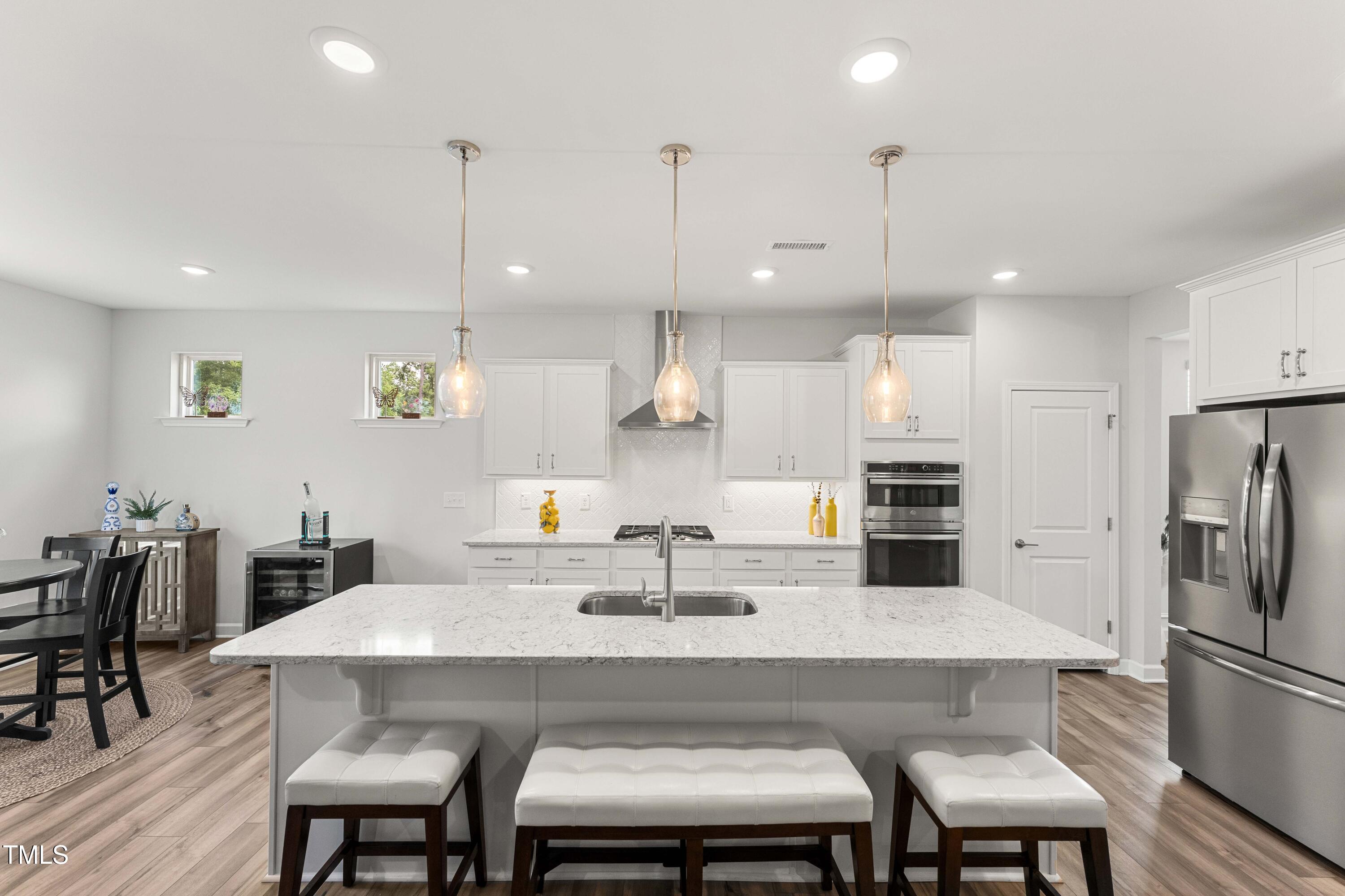 205 Morningside Lane Angier, NC 27501 - Photo 15 of 46 a kitchen with a dining table chairs refrigerator and microwave