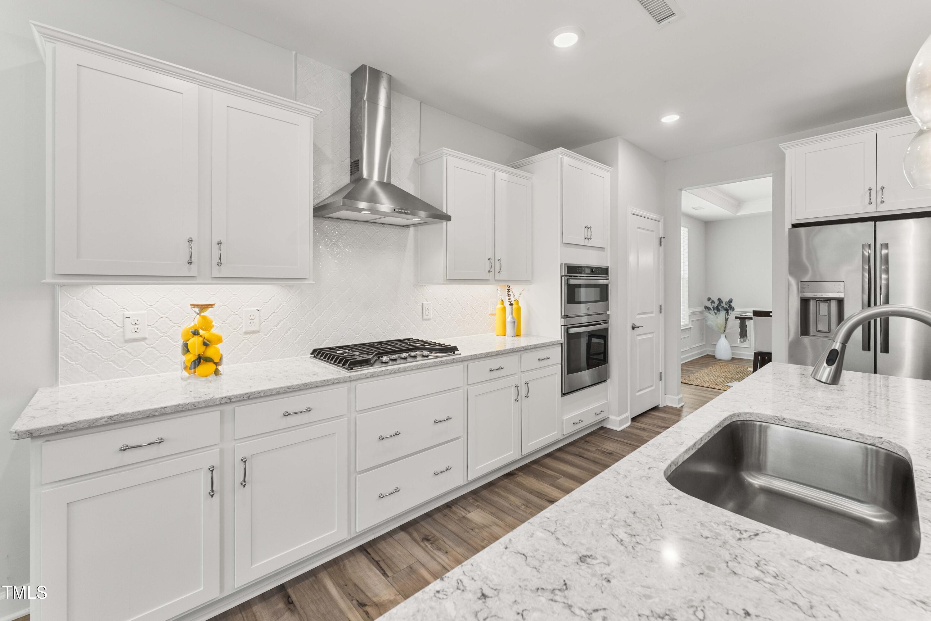 205 Morningside Lane Angier, NC 27501 - Photo 16 of 46 a kitchen with stainless steel appliances kitchen island granite countertop a sink a stove and white cabinets