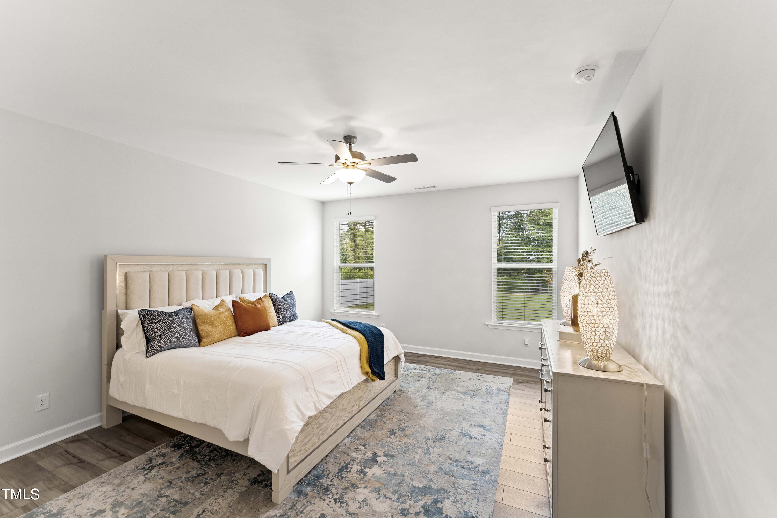 205 Morningside Lane Angier, NC 27501 - Photo 21 of 46 a bedroom with a large bed and a flat tv screen on dresser