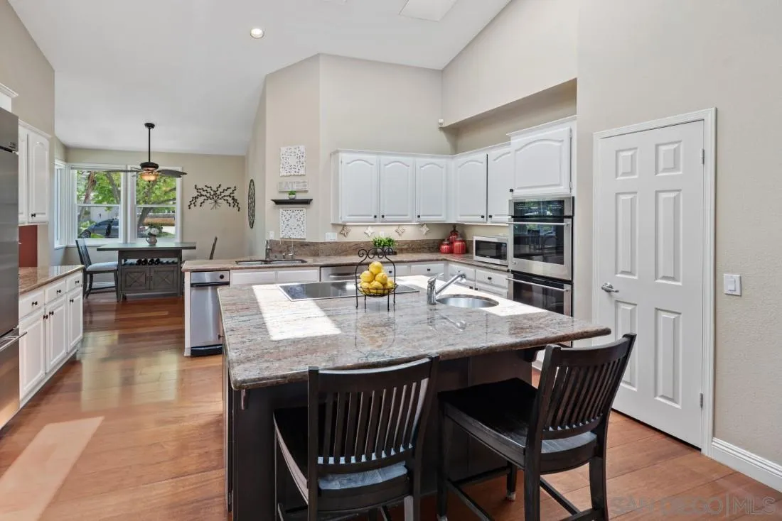 15928 Cumberland Drive Poway, CA 92064 - Photo 17 of 41 a large kitchen with granite countertop a stove a sink a dining table and chairs