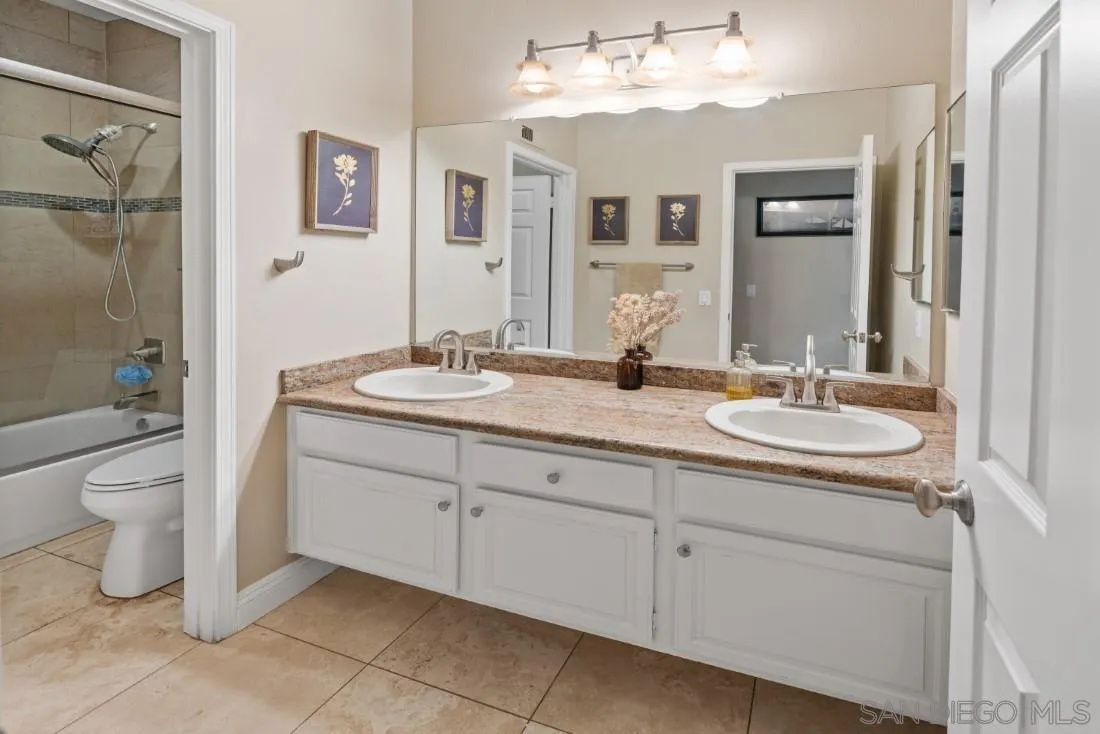 15928 Cumberland Drive Poway, CA 92064 - Photo 28 of 41 a bathroom with a granite countertop sink a toilet and a mirror