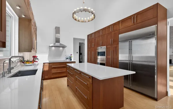a kitchen with stainless steel appliances granite countertop a sink and a refrigerator