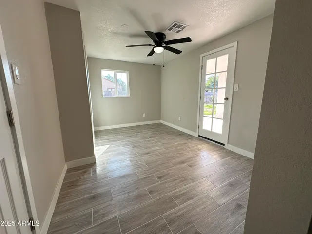 an empty room with wooden floor and windows
