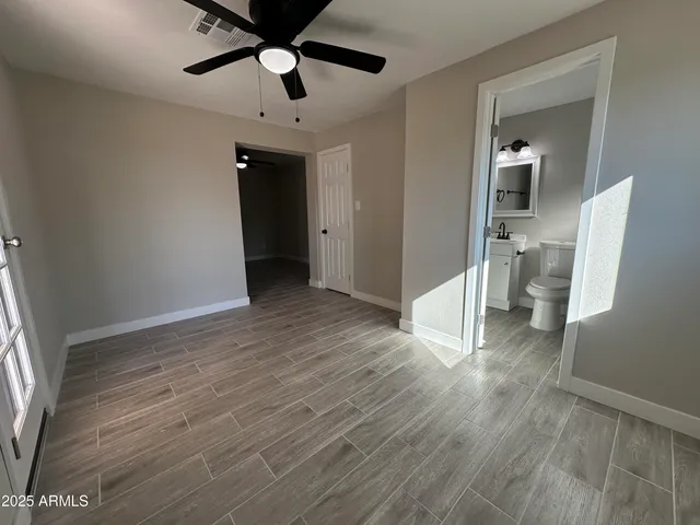 a view of a big room with wooden floor and a ceiling fan