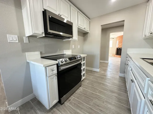 a kitchen with stainless steel appliances a stove microwave and sink