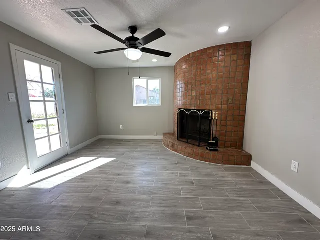 a view of an empty room with a window and a fireplace