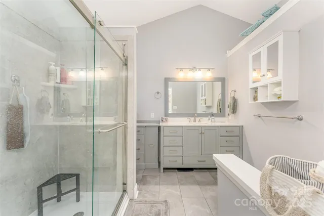 a bathroom with a granite countertop sink mirror and bathtub