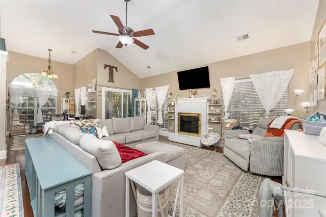a living room with furniture a fireplace and a flat screen tv