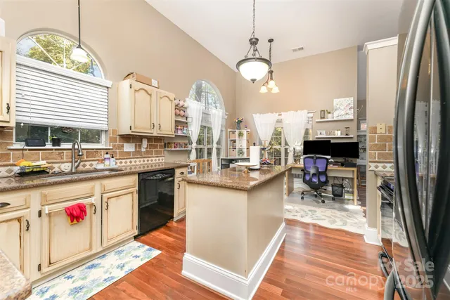 a kitchen with stainless steel appliances granite countertop a stove refrigerator and cabinets