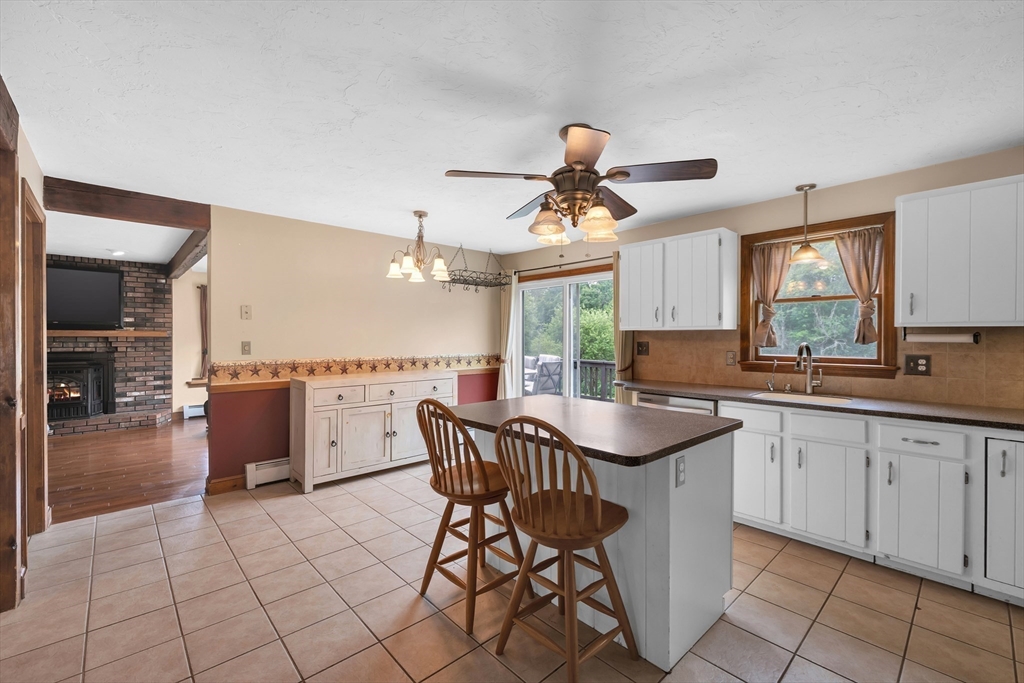 157 Podunk Road Sturbridge, MA 01566 - Photo 11 of 42 a kitchen with stainless steel appliances granite countertop a sink a stove a dining table and chairs