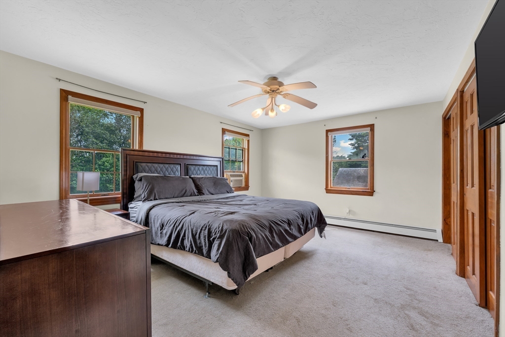 157 Podunk Road Sturbridge, MA 01566 - Photo 20 of 42 a spacious bedroom with a bed and a window