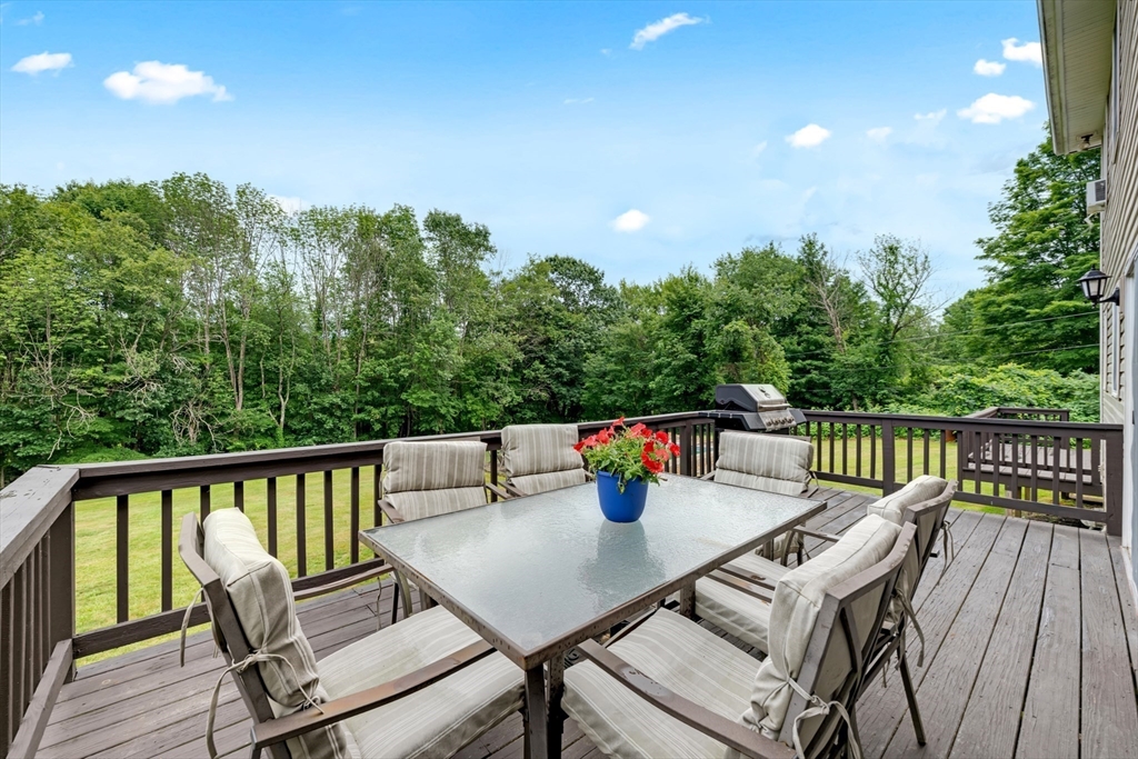 157 Podunk Road Sturbridge, MA 01566 - Photo 34 of 42 a balcony with wooden floor and outdoor seating