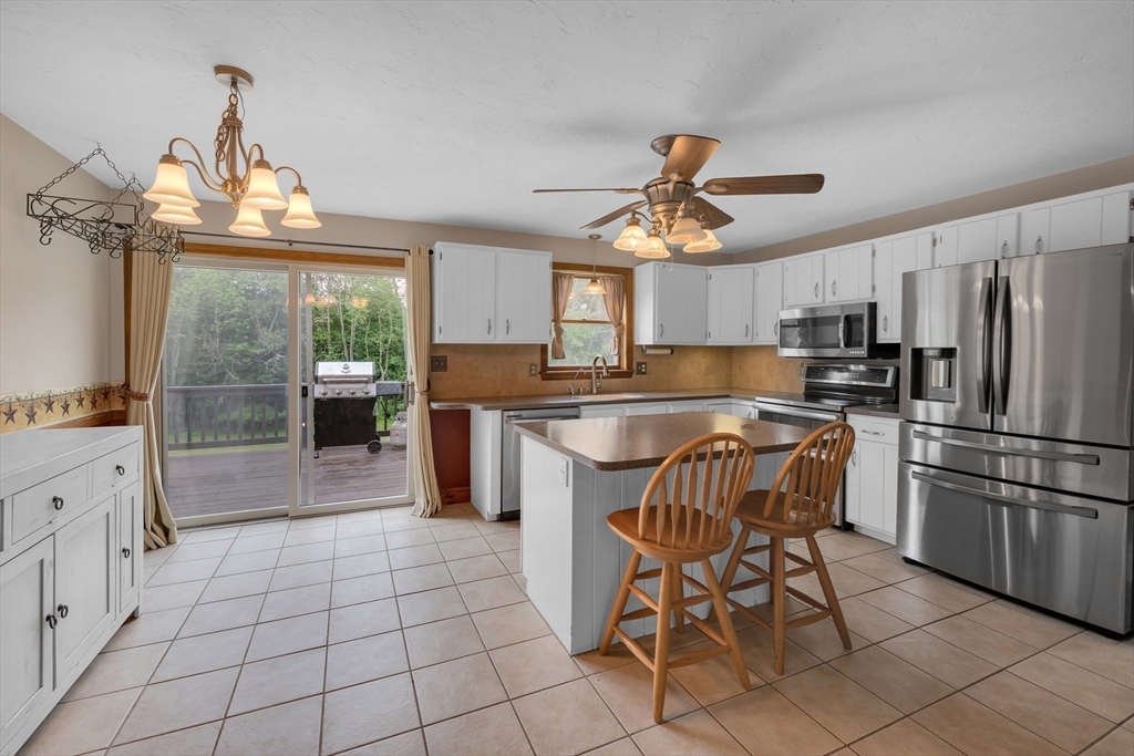 157 Podunk Road Sturbridge, MA 01566 - Photo 9 of 42 a kitchen with stainless steel appliances a stove a refrigerator and a dining table
