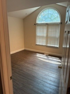 203 Indian Trail Road Seneca, SC 29672 - Photo 6 of 14 An arched window and vaulted ceiling bring architectural character to this bedroom with wood flooring.