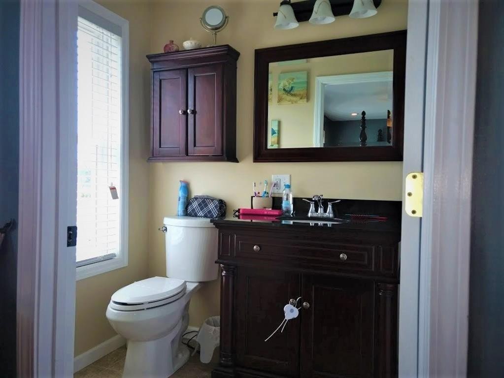 310 Highway 305 Decatur, TN 37322 - Photo 16 of 31 a bathroom with a toilet a sink a vanity and mirror
