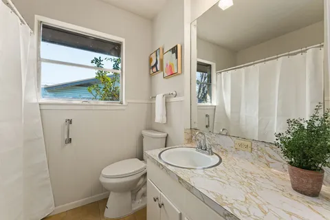 a bathroom with a granite countertop sink toilet and shower