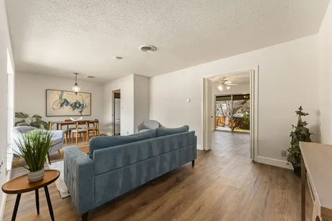 a living room with furniture and a wooden floor