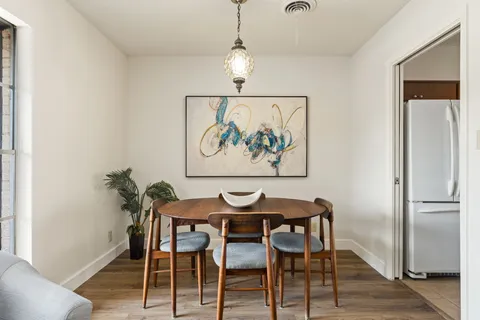 a view of a dining room with furniture wooden floor and a chandelier