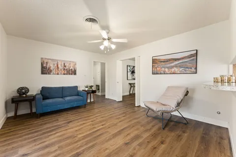 a living room with furniture and a wooden floor