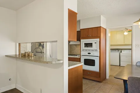 a kitchen with stainless steel appliances granite countertop a refrigerator and a stove top oven
